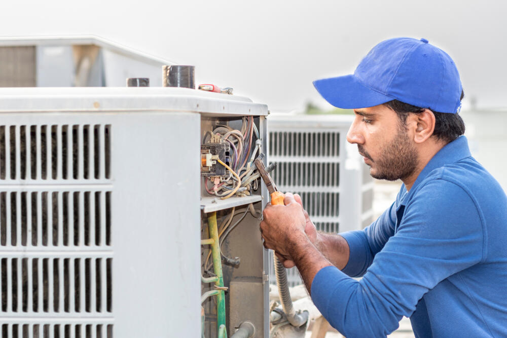 A Budget Heating and Cooling expert working on an HVAC unit